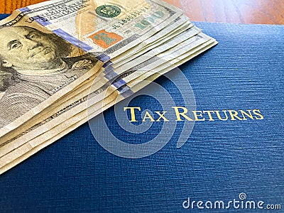 Tax Return Cash Sitting Upon A Blue Leather Tax Portfolio Stock Photo