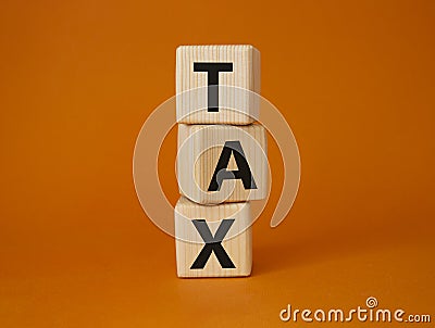 Tax symbol. Wooden cubes with word Tax. Beautiful orange background. Business and Finace and Tax concept. Copy space Stock Photo