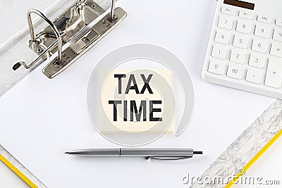 TAX TIME - business concept, message on the sticker on folder background with calculator Stock Photo