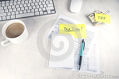 Tax time - Notification of need to file tax returns, tax form at accountant`s workplace. Top view of notepad, stickers, cup of Editorial Stock Photo
