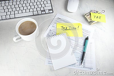 Tax time - Notification of need to file tax returns, tax form at accountant`s workplace. Top view of notepad, stickers, cup of Stock Photo