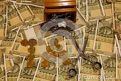 Tax word spelled out with coins and scissor. Stock Photo