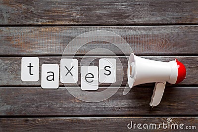 Taxes announcement with megaphone and text on wooden background top view Stock Photo