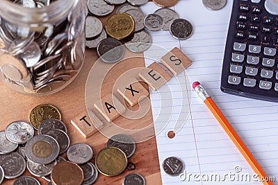 `Taxes` spelled out in wooden letter tiles Editorial Stock Photo
