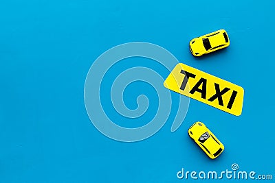 Taxi concept. Yellow service sign text taxi near car toy on blue background top view space for text Stock Photo