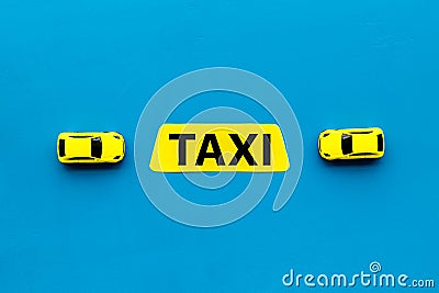 Taxi concept. Yellow service sign text taxi near car toy on blue background top view space for text Stock Photo