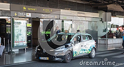 Taxi dropping off its passenger in front of the check-in and departures entrance of Terminal 1 of Lisbon International Airport Editorial Stock Photo