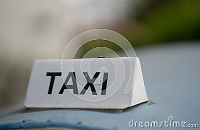 A taxi sign with out-of-focus green vegetation in a city or village. Retro city transport Stock Photo