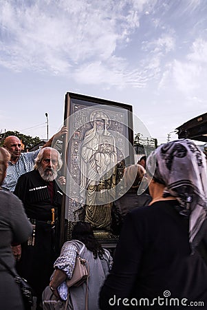 Tbilisi, Georgia: Believer piligrims praying near Orthodox Saint icon Editorial Stock Photo