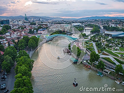 Tbilisi, Georgia - June 2018: Rike Park, Kura River, Peace Bridge and funicular at sunset, aerial view Editorial Stock Photo