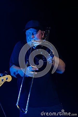 TBILISI, GEORGIA - OCTOBER 23, 2022: A singer sings a song on stage. Musical performance at a rock band concert. The trumpeter Editorial Stock Photo