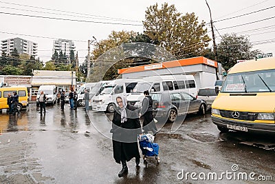 Tbilisi, Georgia. Woman Walks Near Urban Taxis Minibuses Are On Editorial Stock Photo