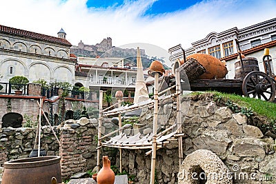 Tbilisi street. National Georgian flavor. Pitchers, millstones, arba, wine barrels. Georgia Stock Photo