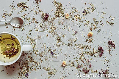 Tea background. Dry herbal tea and cup of hot tea with spoon on the gray background. Copy space Stock Photo