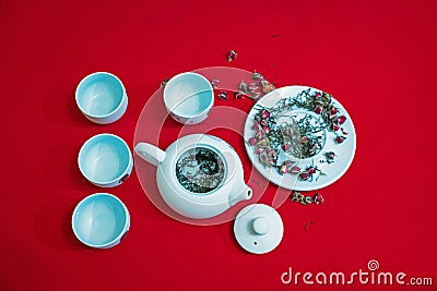 Tea composition with Chinese traditional tea cups and teapot on the background of red velvet fabric. Stock Photo