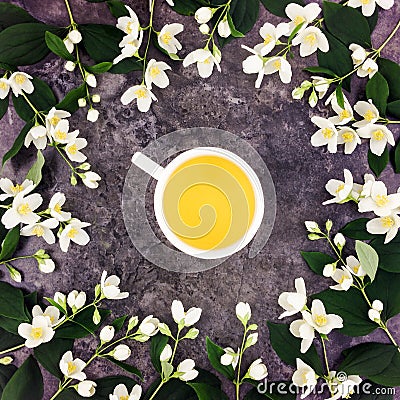 Tea cup with green tea and jasmine flowers on stone background. Top view, flat lay Stock Photo