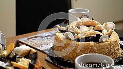 Tea cups mugs with two dessert cake tarts on wooden table at home Stock Photo