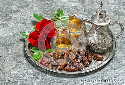Tea, dates fruits and flowers. Islamic holidays decoration. Eid Stock Photo