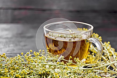 Tea of gray wormwood in glass cup on dark board Stock Photo