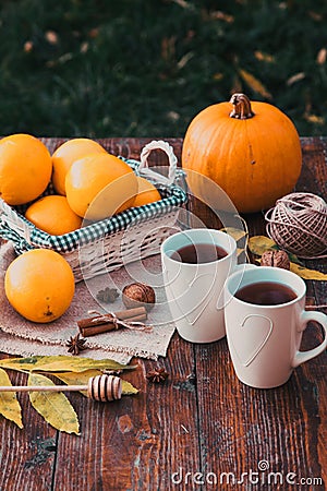 tea with lemon, honey, oranges, autumn leaves on woodenbackground Stock Photo