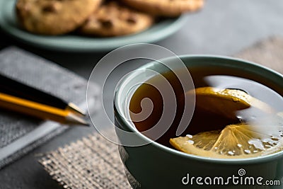 Tea with lemon, peanuts cookies and gray notebook with pen and pencil Stock Photo