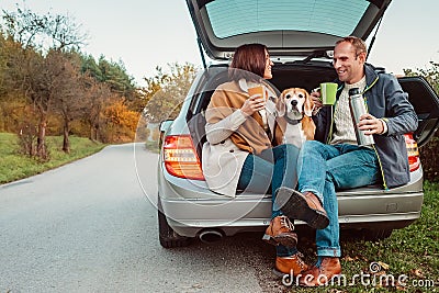 Tea party in car truck - loving couple with dog sits in car truck Stock Photo