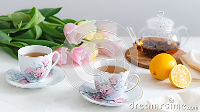 Tea party with homemade cake, lemon, teapot and tulips on the background. Spring mood, Mother`s day concept. Copy space Stock Photo