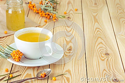 Tea with sea-buckthorn orange berries in a cup and organic honey Stock Photo