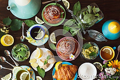 Tea set: Green tea with lemon and mint and different baked goods with a crispy crust on the wooden background Stock Photo