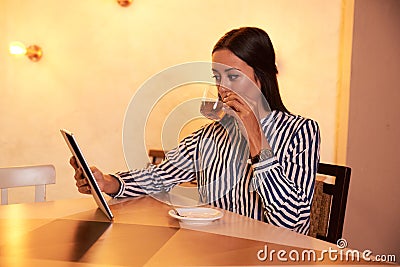 Tea sipping lady with a tablet Stock Photo