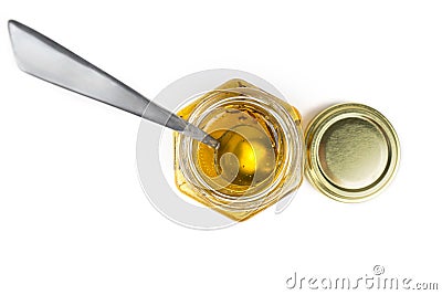 Tea spoon in a hexagonal honey jar isolated on white. Top view Stock Photo