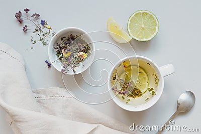 Tea time. Cup of hot herbal tea and dry tea on the gray background, top view Stock Photo