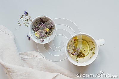 Tea time. Cup of hot herbal tea and dry tea on the gray background, top view Stock Photo