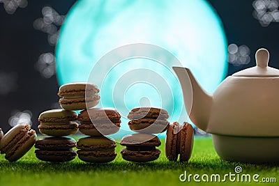 Tea time, oriental tales, teapot with french sweets macaroons, starry sky and moon. Delicious and spicy tea Stock Photo