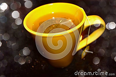 Teabag in a yellow tea cup with filter effect Stock Photo