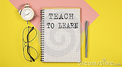TEACH TO LEARN text on the notebook with pen on yellow background with pen, glasses and alarm cloack Stock Photo