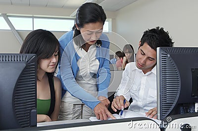 Teacher Assisting Students In Computer Lab Stock Photo