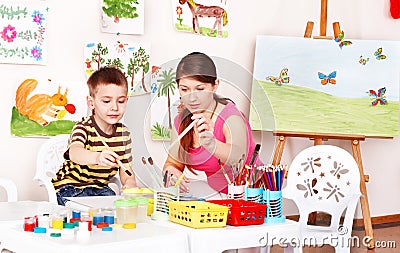 Teacher and boy learn draw in play room. Stock Photo