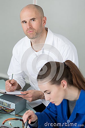 teacher checking on student in robotic class with pcb Stock Photo