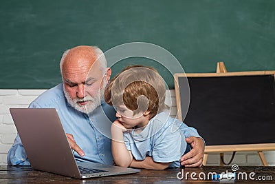 Teacher and child. His enjoys talking to grandfather. Daddy and son together. Young serious male Pupil studying in Stock Photo