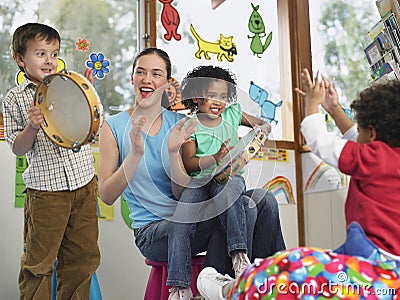 Teacher With Children Playing Music In Class Stock Photo