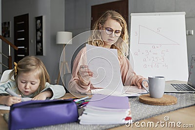 Teacher conducts classes online and takes care of the daughter Stock Photo