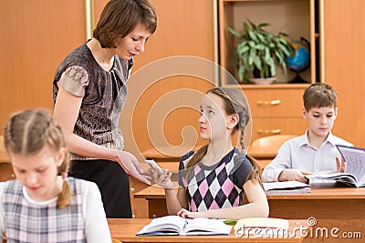 Teacher confiscating mobile phone at lesson in school Stock Photo