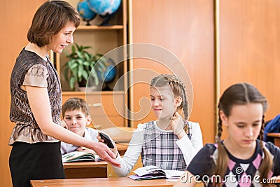 Teacher confiscating school kid's mobile phone at lesson Stock Photo