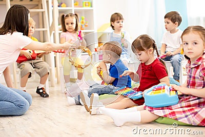 Teacher and cute kids during music lesson in preschool Stock Photo