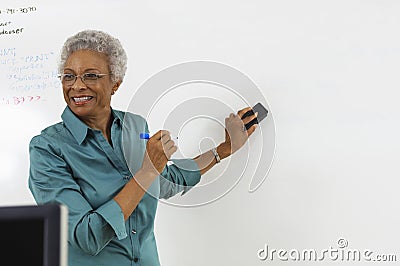 Teacher Erasing Text On Whiteboard Stock Photo