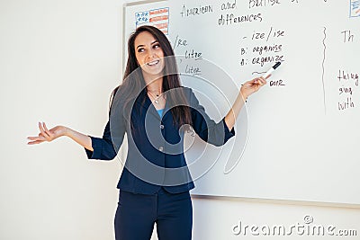 Teacher explaining differences between American and British spelling writing on whiteboard English language school Stock Photo