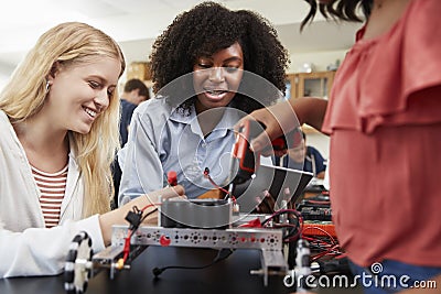 Teacher With Female Pupils Building Robotic Vehicle In Science Lesson Stock Photo