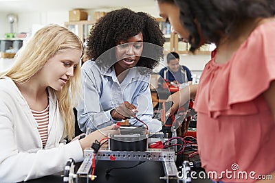 Teacher With Female Pupils Building Robotic Vehicle In Science Lesson Stock Photo