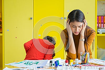 Teacher get headache with two naughty kids in classroom at kindergarten school. Stock Photo